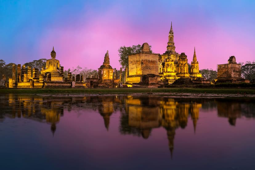 The scene features a majestic Thai temple, with its intricate architecture and vibrant colors standing out against a clear sky. The temple's ornate golden spires and tiered roofs are adorned with detailed carvings and decorative elements, reflecting traditional Thai design.